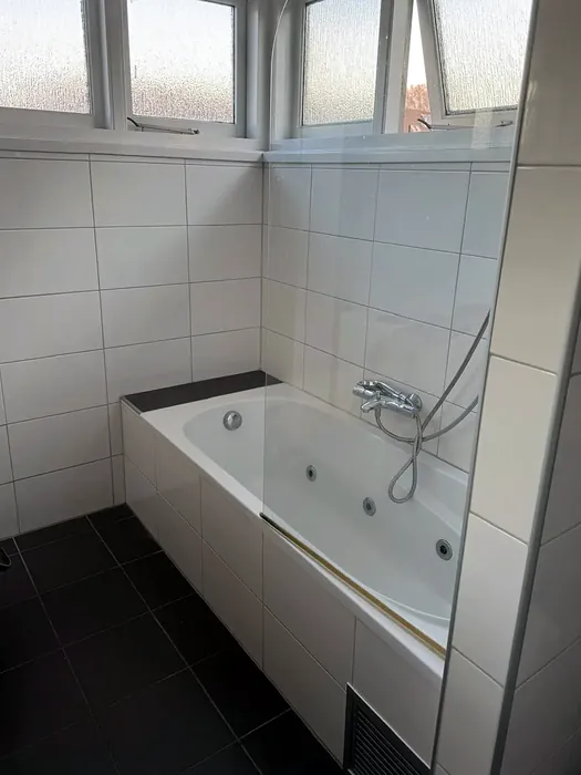 Voor: ligbad met bubbelfunctie onder drie ramen